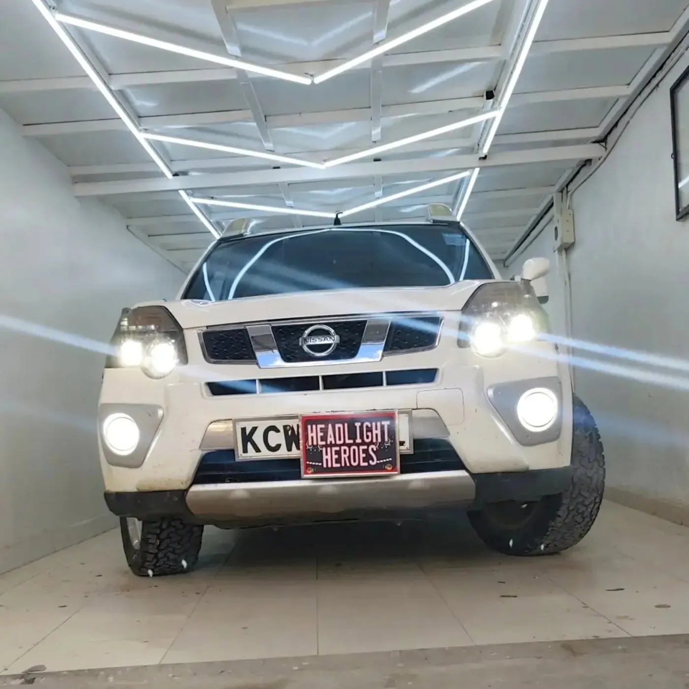 Nissan X-Trail in the bay with lights on